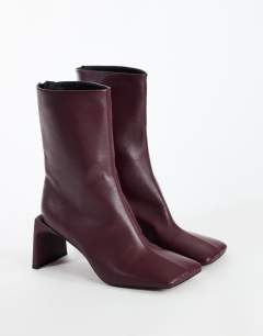 Model wearing Kane angular heeled ankle boot in aubergine