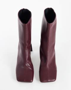 Model wearing Kane angular heeled ankle boot in aubergine