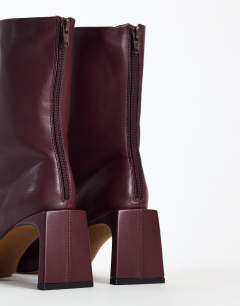 Model wearing Kane angular heeled ankle boot in aubergine