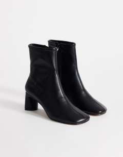 Model wearing Kenna block heel ankle boot in black