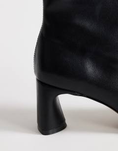 Model wearing Kenna block heel ankle boot in black