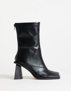 Model wearing Kiara extended rand heeled ankle boot in black