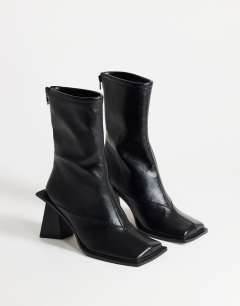 Model wearing Kiara extended rand heeled ankle boot in black