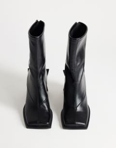 Model wearing Kiara extended rand heeled ankle boot in black