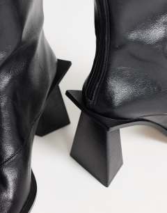Model wearing Kiara extended rand heeled ankle boot in black