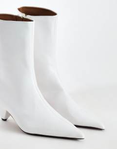 Model wearing Kiki cone heel ankle boot in off white
