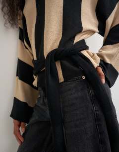 Model wearing Knited long sleeve tie front jumper in mono stripe
