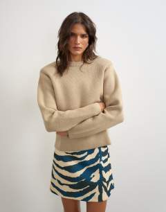 Model wearing Knitted all needle shoulder padded jumper in oat