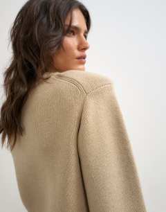 Model wearing Knitted all needle shoulder padded jumper in oat