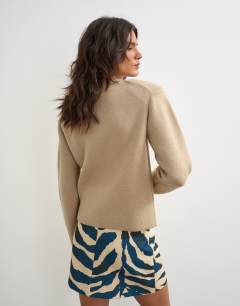 Model wearing Knitted all needle shoulder padded jumper in oat