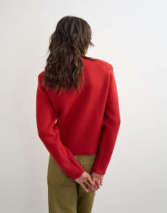 Model wearing Knitted all needle shoulder padded jumper in red