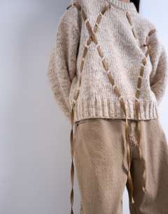 Model wearing Knitted argyle jumper with suede strap detailing in brown