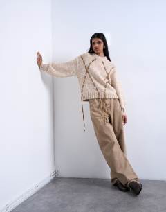 Model wearing Knitted argyle jumper with suede strap detailing in brown