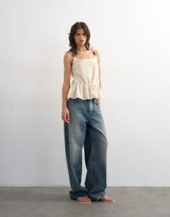 Model wearing Knitted beaded draw waist peplum tank in ivory