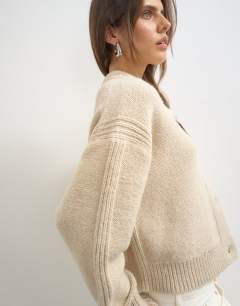 Model wearing Knitted boxy deep rib cardigan in latte