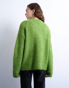 Model wearing Knitted boxy fluffy crew jumper in green