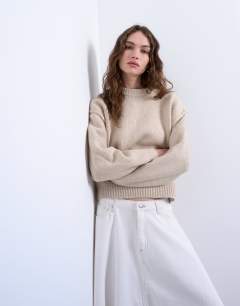 Model wearing Knitted boxy wide sleeve mid crew jumper in oat