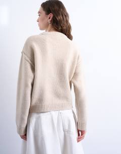 Model wearing Knitted boxy wide sleeve mid crew jumper in oat