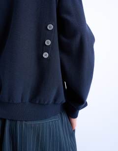 Model wearing Knitted button back jumper in navy