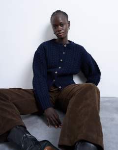 Model wearing Knitted cable fitted waist cardigan in navy
