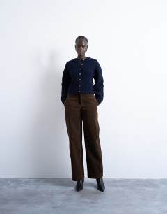 Model wearing Knitted cable fitted waist cardigan in navy