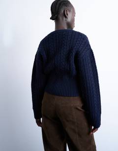 Model wearing Knitted cable fitted waist cardigan in navy