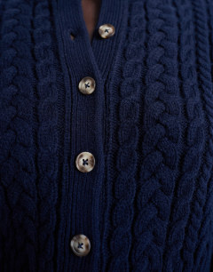 Model wearing Knitted cable fitted waist cardigan in navy