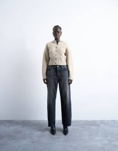 Model wearing Knitted cable fitted waist cardigan in oat