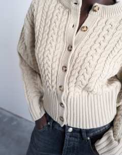 Model wearing Knitted cable fitted waist cardigan in oat