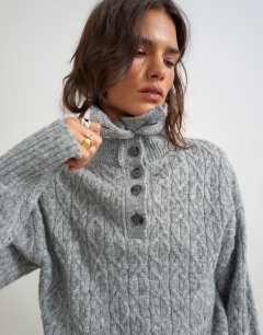 Model wearing Knitted cable stitch funnel neck jumper in grey