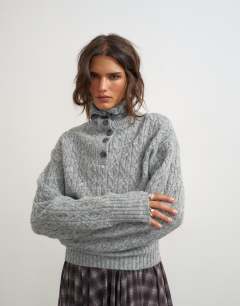 Model wearing Knitted cable stitch funnel neck jumper in grey