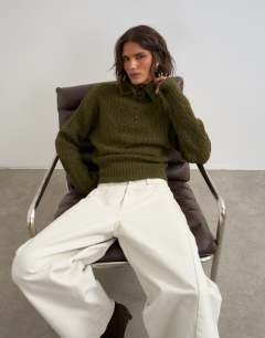 Model wearing Knitted cable stitch funnel neck jumper in moss