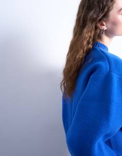 Model wearing Knitted chunky all needle clean crew jumper in Blue