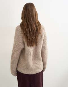 Model wearing Knitted chunky shawl collar jumper in oat