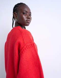 Model wearing Knitted clean exposed seam jumper in red