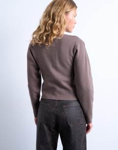 Model wearing Knitted compact balloon sleeve cardigan in oat