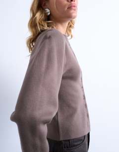 Model wearing Knitted compact balloon sleeve cardigan in oat
