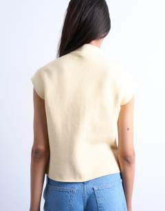 Model wearing Knitted compact cap sleeve waistcoat in Buttermilk