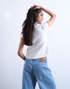 Model wearing Knitted compact cap sleeve waistcoat in Ivory