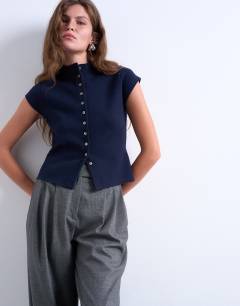 Model wearing Knitted compact cap sleeve waistcoat in Navy