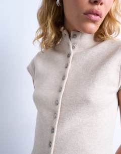 Model wearing Knitted compact cap sleeve waistcoat in oat