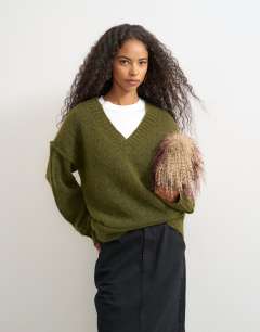 Model wearing Knitted deep v neck jumper with wool in moss