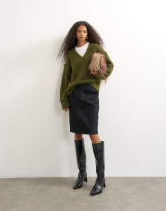 Model wearing Knitted deep v neck jumper with wool in moss