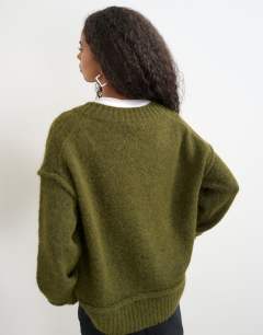 Model wearing Knitted deep v neck jumper with wool in moss