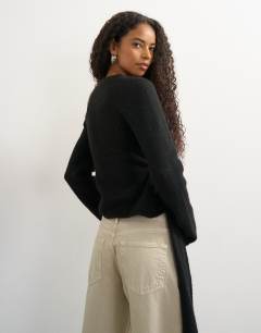 Model wearing Knitted drape hem jumper with wool in black 