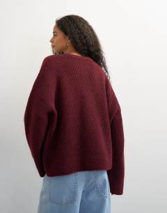Model wearing Knitted easy Henley jumper in burgundy