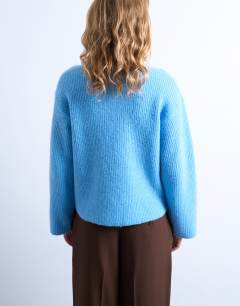 Model wearing Knitted easy ribbed relaxed cardigan in blue
