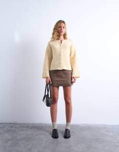 Model wearing Knitted easy ribbed relaxed cardigan in buttermilk