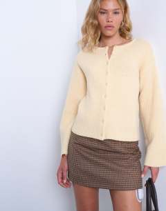 Model wearing Knitted easy ribbed relaxed cardigan in buttermilk