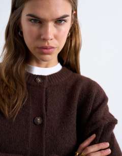Model wearing Knitted exposed seam relaxed cardigan in brown